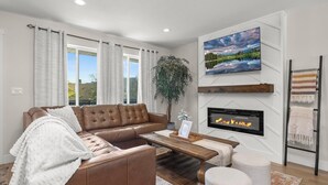 A modern living room with a leather sofa, a wooden coffee table, and a fireplace.