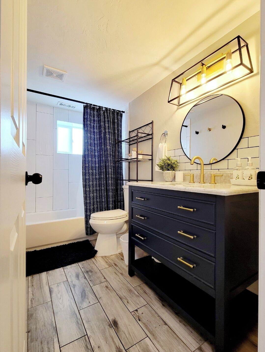 A modern bathroom with a bathtub, toilet, and vanity with a mirror.