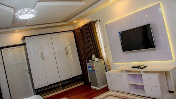 Une chambre moderne équipée d’une télévision, d’une armoire et d’un petit bureau.
