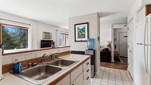 Une cuisine moderne équipée de deux éviers, d’un distributeur d’eau et d’un réfrigérateur.