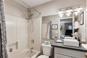 Une salle de bain équipée d’une douche, de toilettes, d’un lavabo et d’un meuble-lavabo.
