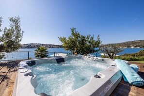 Un bain à remous avec vue sur un lac et une ville située au loin.
