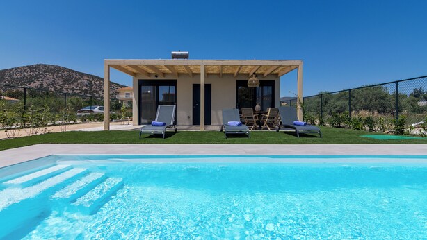 A modern house with a pool, two lounge chairs, and a pergola. - Elegant house with Private Pool (Schinias)