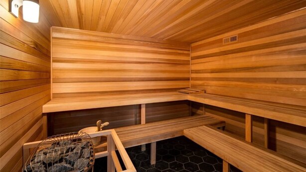 Sauna, jossa on puiset lauteet ja kivinen lattia.