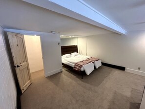 A bedroom with a bed, a door, and a ceiling light. - Ski Condo at Base - Walk to Gondola & Dining! (Steamboat Springs)