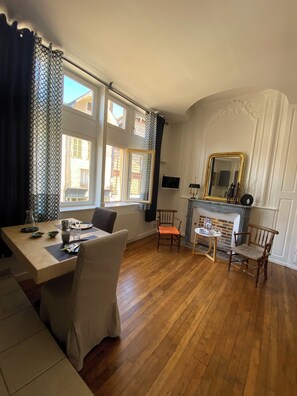 A dining area with a wooden table, chairs, and a fireplace.
