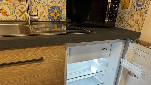 A kitchen with a built-in refrigerator, a sink, and a microwave. - Holiday home Alpine Serenity  (Aosta)