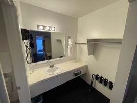 Bañera con ducha, toallas, jabón, shampoo