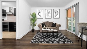 Uma sala de estar moderna com sofá, mesa de centro e obras de arte na parede.
