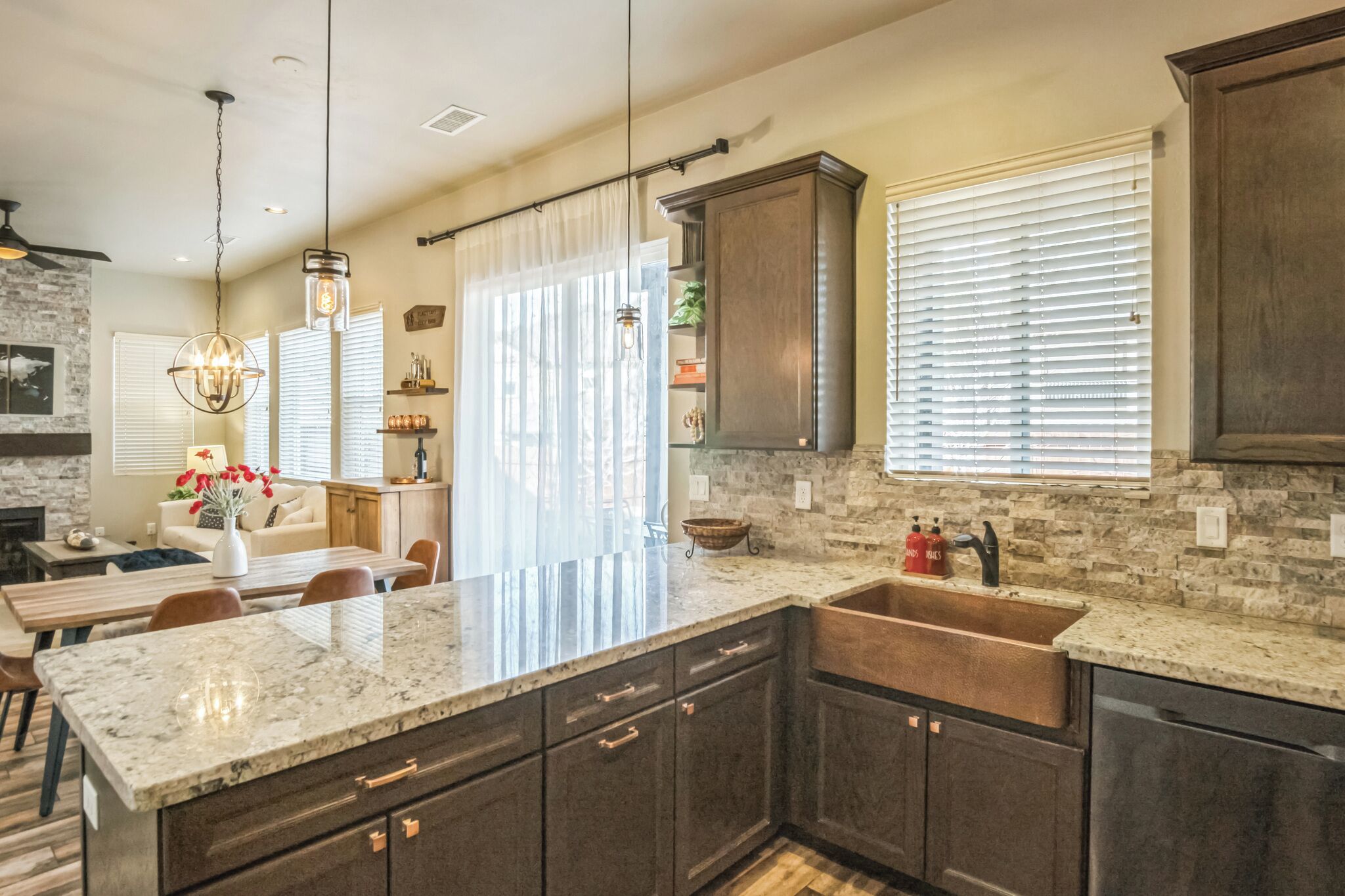 A modern kitchen with granite countertops, dark cabinetry, and a large island.
