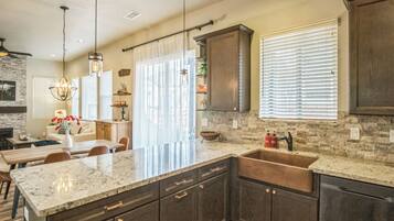 A modern kitchen with granite countertops, dark cabinetry, and a large island.