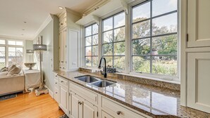 A kitchen with a large window, wooden cabinets, and a granite countertop. - Groton Home < 1 Mi to Beach on Long Island Sound! (Groton)