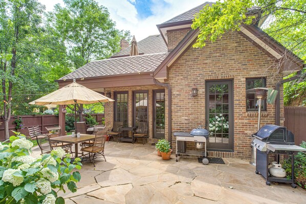 A brick house with a patio, outdoor seating, and a grill. - Walk to DU, Dining & Parks: Spacious Denver Home! (Denver)