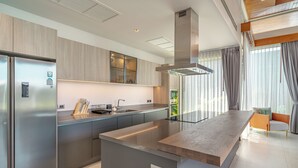 Una cocina moderna con una isla central, electrodomésticos de acero inoxidable y un diseño contemporáneo.
