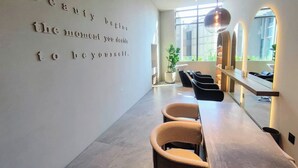 A modern interior with a motivational quote on the wall, a seating area with chairs, and a large mirror.