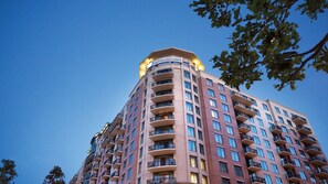 Un hotel de varios pisos con un llamativo letrero de 'WYNDHAM' en la parte superior, que presenta un diseño arquitectónico moderno con balcones en cada planta.