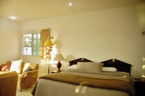 Relax in comfort with a large bed, bedside table, and sofa in this inviting space.