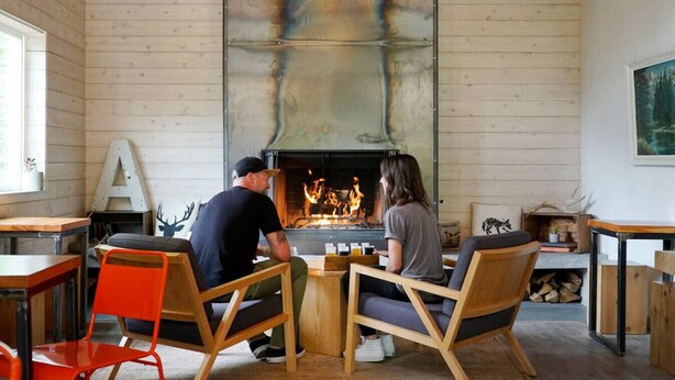 Une pièce chaleureuse avec une cheminée, des meubles en bois et un grand tableau accroché au mur.