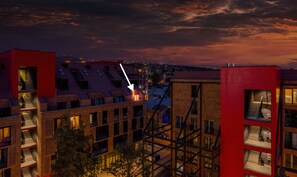 Un edificio moderno en la ciudad con varios balcones y fachada roja.