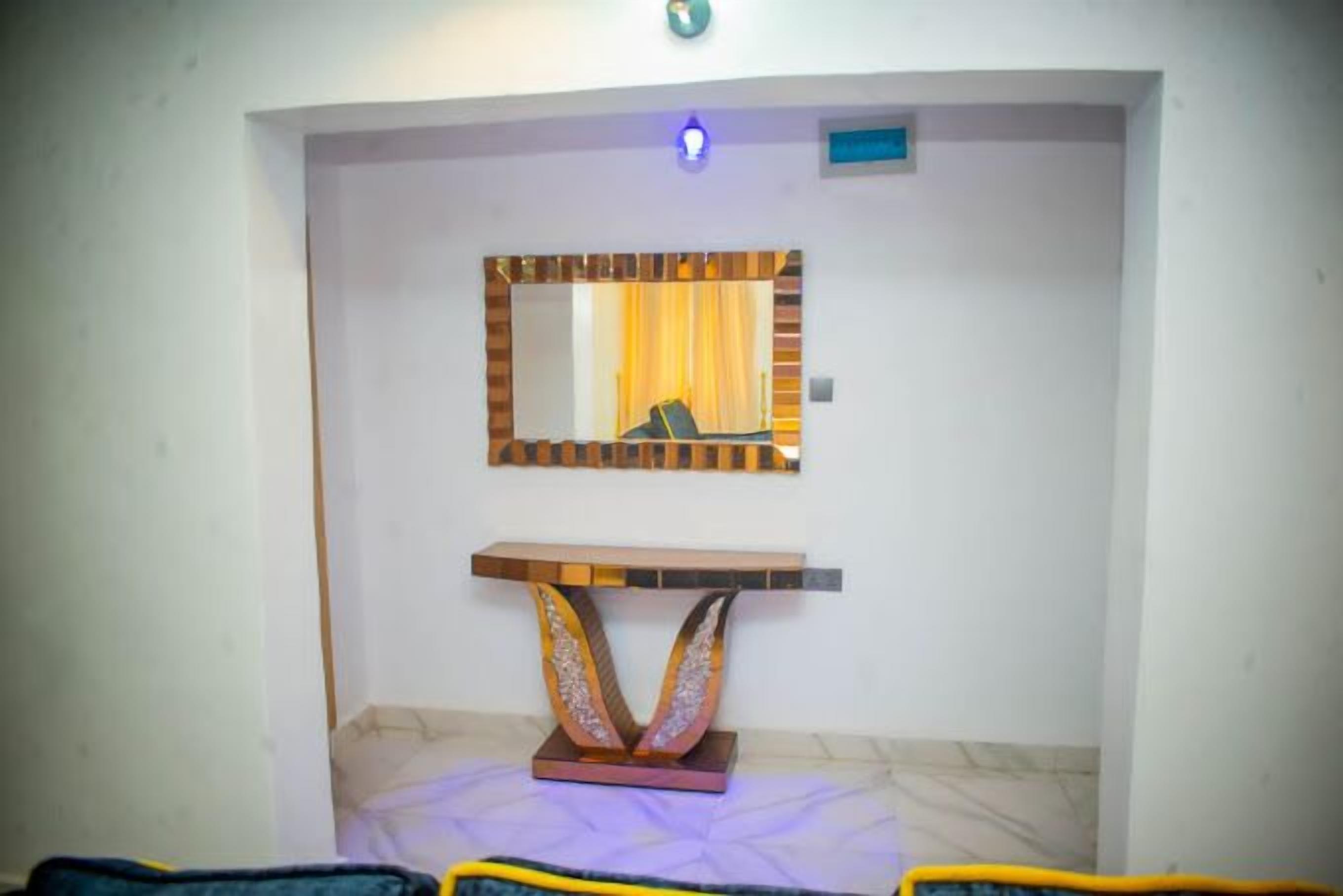 A room with a mirror, a wooden console table, and a patterned rug.