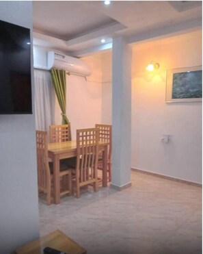 Enjoy meals at the dining table with four chairs, and relax with a flat-screen TV on the wall.