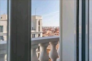 Enjoy breathtaking views of the city from this balcony overlooking a vibrant urban landscape.