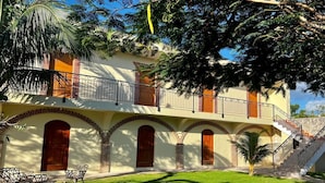 A two-story building with a balcony, arched doorways, and a staircase. - Hotel Yamilí (Punta Cana)