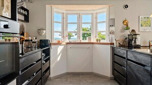 Una cocina con ventanal, electrodomésticos integrados y vistas al exterior.