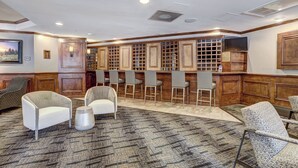 A hotel lobby with a reception desk, bar area, and seating. - Downtown Breck Base Camp — Walk to Main St & Gondola — Pool + Hot Tubs (Breckenridge)