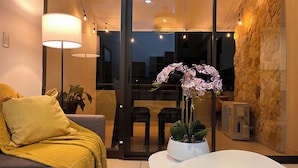 A modern living room with a sofa, a coffee table, and a potted plant.