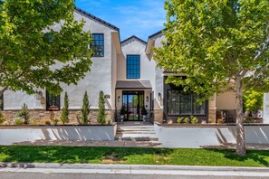 A modern two-story house with a stone facade, a front porch, and a well-maintained lawn. - Our Place; Our Home has an inside slide, gourmet kitchen, view for days, and just feels like home! (Hurricane)