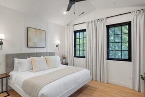 A bedroom with a large bed, two windows with curtains, a ceiling fan, and a wall-mounted light fixture. - Our Place; Our Home has an inside slide, gourmet kitchen, view for days, and just feels like home! (Hurricane)