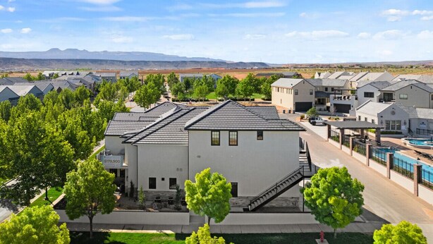 A residential area with modern houses, a swimming pool, and a clear view of distant mountains. - Our Place; Our Home has an inside slide, gourmet kitchen, view for days, and just feels like home! (Hurricane)