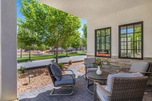 A patio with wicker furniture, a round table, and a potted plant. - Our Place; Our Home has an inside slide, gourmet kitchen, view for days, and just feels like home! (Hurricane)