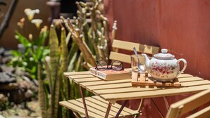 Una mesa de madera con una tetera, un libro y vasos.