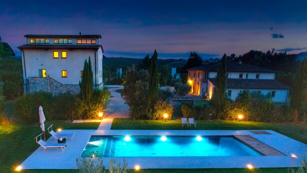 A modern house with a swimming pool, surrounded by a well-maintained lawn and trees. - Design Loft Apartment (Marsciano)