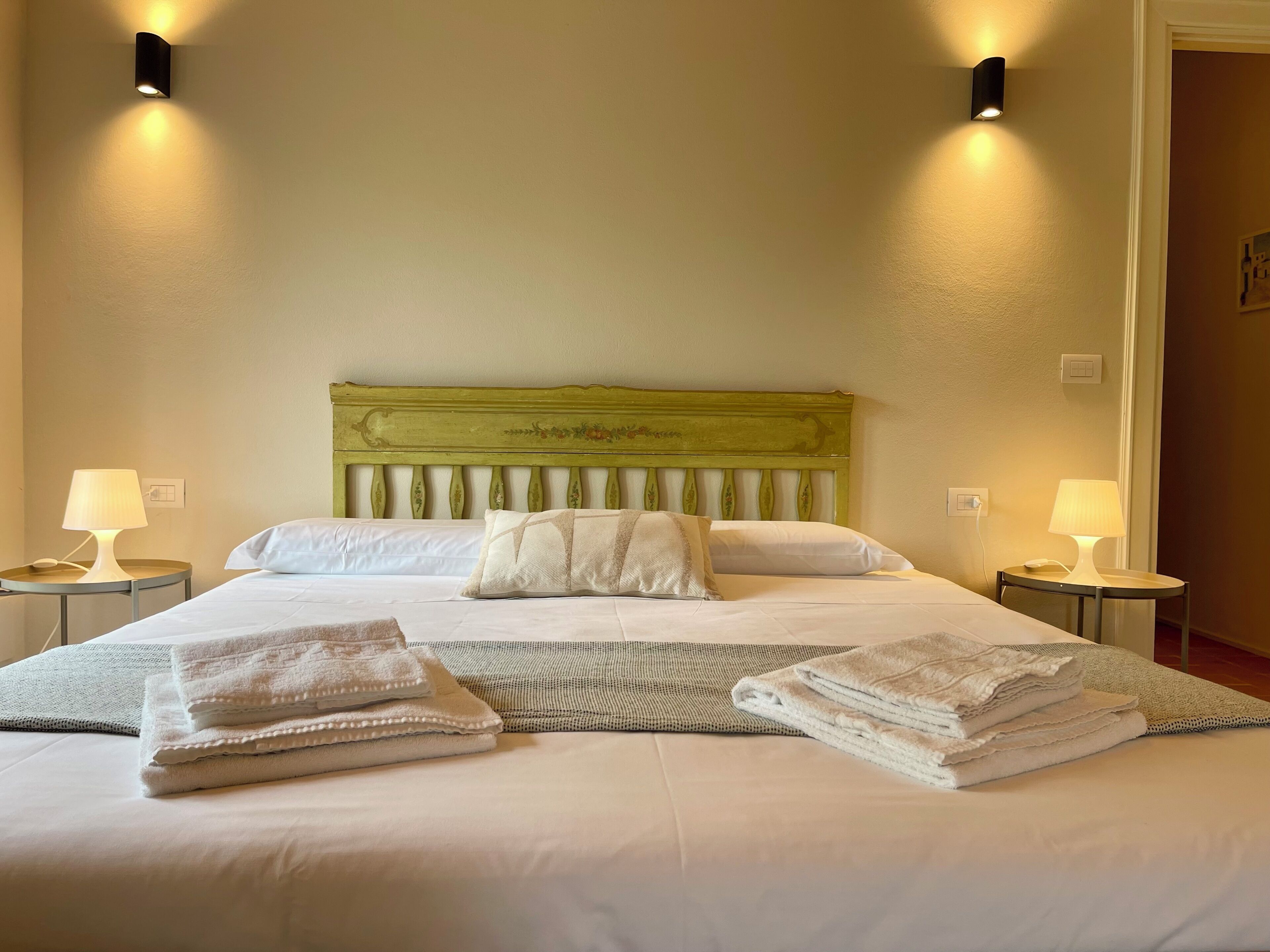 Une chambre d’hôtel avec un lit, deux lampes de chevet et une tête de lit.