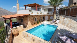 A poolside area with a stone pool, lounge chairs, and a pergola. - Private Pool, Sunny Location, South Rethimno, Ideal for Adults (Saktouria)