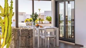 A patio with a stone wall, white furniture, and potted plants. - BLASCO by Buenavilla | luxury and comfort in an unrivalled setting (Puerto Calero)