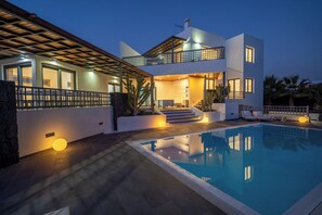 A modern two-story house with a swimming pool, outdoor lighting, and a covered patio area. - BLASCO by Buenavilla | luxury and comfort in an unrivalled setting (Puerto Calero)
