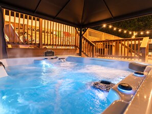 A hot tub with a wooden deck and a sign indicating a $50 fee for entry.