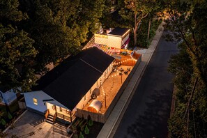 A rooftop with a swimming pool, outdoor seating, and a covered area with string lights. - Hot Tub & Sauna | Newly Renovated Outside (Charlotte)