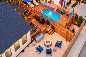 A backyard with a swimming pool, deck chairs, a hot tub, and a fire pit. - Hot Tub & Sauna | Newly Renovated Outside (Charlotte)