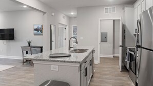 A modern kitchen with granite countertops, stainless steel appliances, and a central island.