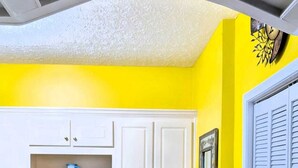 A kitchen with white cabinets, a stainless steel dishwasher, and a yellow wall. - Cozy 2BR Retreat • Near Lake Lanier & Mall of GA • Private, Peaceful, Festive


 (Sugar Hill)