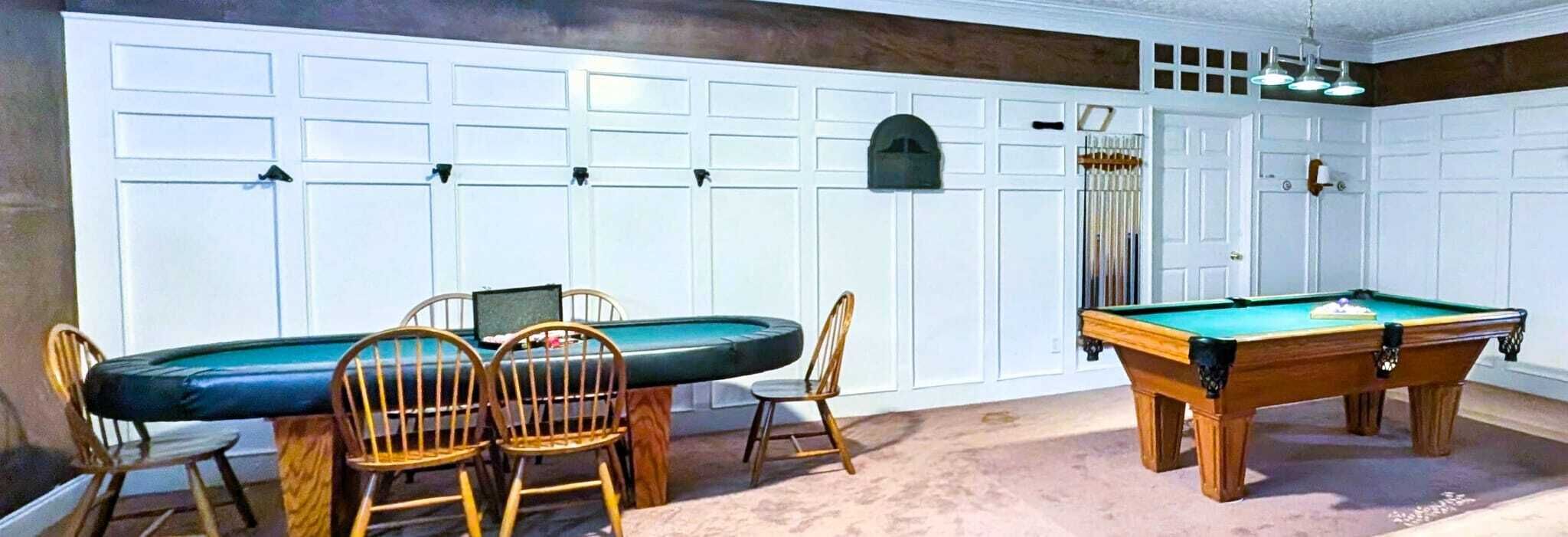 A pool table with chairs, a pool table, and a pool table in a room with a white wall and a door.