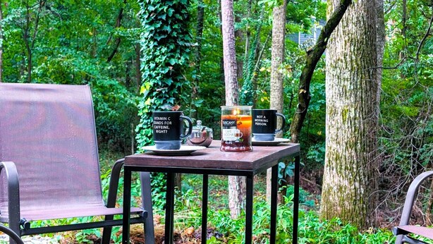 A table with two cups and a candle in a forest setting. - Cozy 2BR Retreat • Near Lake Lanier & Mall of GA • Private, Peaceful, Festive


 (Sugar Hill)