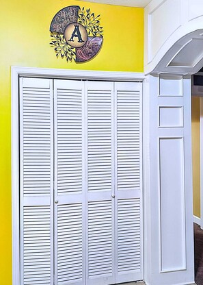 A white louvered closet door with a decorative circular sign above it. - Cozy 2BR Retreat • Near Lake Lanier & Mall of GA • Private, Peaceful, Festive


 (Sugar Hill)
