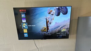 Un televisor de pantalla plana montado en la pared mostrando un perfil de Netflix con las opciones 'Haku Guest' y 'Salvando el Fondo de Bikini'.