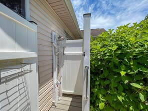 A white door with a glass panel, a metal handle, and a metal shelf attached to the door frame.